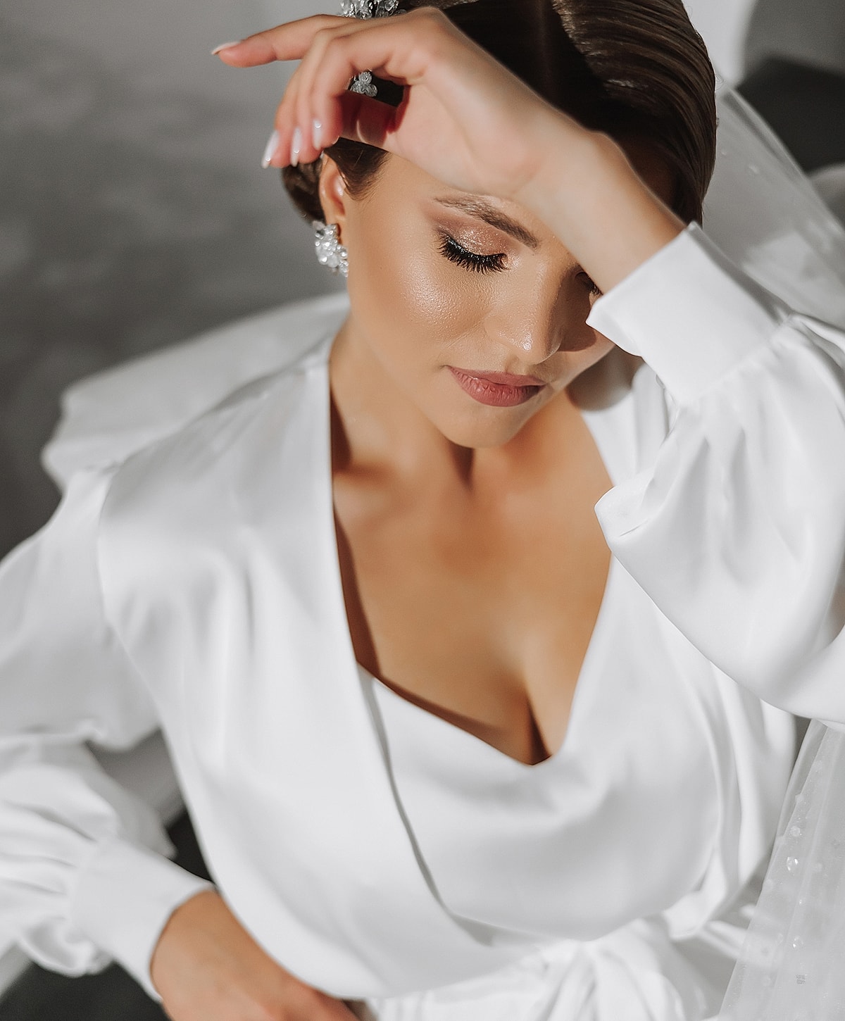 Bride in elegant white dress, serene expression.